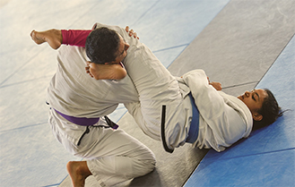 マットの上で三角締めをかけている様子の画像